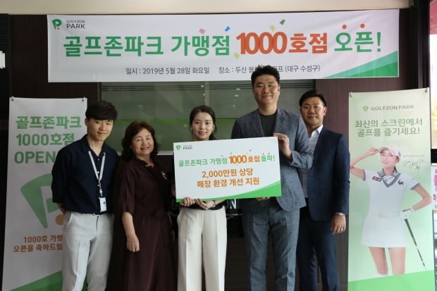 골프존파크 가맹점 1000호 매장인 두산 블랙스톤점의 김애현 대표(가운데)와 골프존 영남사업팀 황윤 팀장(우측 두번째) 및 관계자들이 1000호점 달성 기념촬영을 하고 있다. 골프존 제공