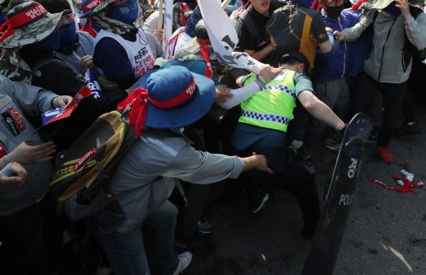 금속노조 대우조선지회와 현대중공업지부 조합원들이 현대중공업 사옥 앞에서 집회를 하던 중 경찰을 끌어내 폭행하고 있다. 사진=연합뉴스