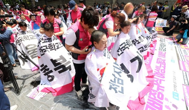  민주노총 전국학교비정규직노조가 17일 오전 청와대 앞에서 학교비정규직 여성노동자 100인 집단삭발식을 하고 있다. [사진=연합뉴스]