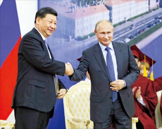 시진핑 중국 국가주석(왼쪽)이 지난 6일 상트페테르부르크대에서 명예박사 학위를 받은 뒤 푸틴 대통령과 악수하고 있다.  AP연합뉴스 