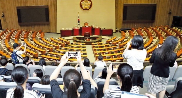 < 텅 빈 국회…견학 온 학생들 > 12일 서울 여의도 국회를 찾은 학생들이 스마트폰으로 텅 빈 본회의장 사진을 찍고 있다. 여야는 이날 국회 정상화를 위한 물밑 접촉을 이어갔지만 국회 정치개혁특별위원회와 사법개혁특별위원회 활동 기한 연장을 놓고 이견을 좁히지 못했다.  /연합뉴스 