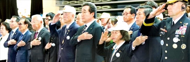 25일 서울 장충체육관에서 열린 6·25전쟁 제69주년 행사에서 참석자들이 국기에 경례하고 있다. 이날 행사에는 이낙연 국무총리(앞줄 오른쪽 네 번째)와 정경두 국방부 장관(두 번째), 로버트 에이브럼스 한미연합사령관(첫 번째) 등 한·미 양국의 정부 및 군 고위관계자들과 ‘1월의 전쟁영웅’으로 선정된 고(故) 김영옥 대령의 조카 다이앤 맥매스 등 유공자와 가족들이 참석했다.    /연합뉴스