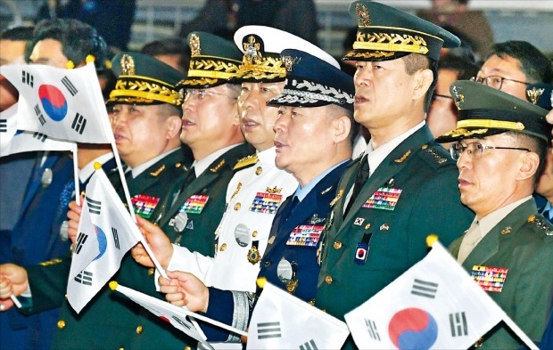 < 태극기 흔드는 軍 수뇌부 > 서울 장충체육관에서 25일 열린 6·25 제69주년 행사에서 참석자들이 애국가를 부르고 있다. 왼쪽부터 박한기 합참의장, 서욱 육군참모총장, 심승섭 해군참모총장, 원인철 공군참모총장, 최병혁 한미연합사령부 부사령관, 이승도 해병대사령관.  /신경훈  기자 khshin@hankyung.com 