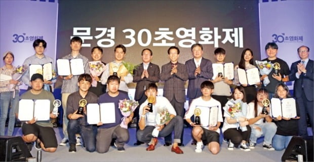 ‘제1회 문경 30초영화제’ 시상식이 지난 29일 경북 문경시 문경 에코랄라 에코스튜디오에서 열렸다. 고윤환 문경시장(뒷줄 오른쪽 여섯 번째), 유근석 한국경제신문 이사(맨 오른쪽)가 수상자들과 함께 기념촬영하고 있다.  /문경=김범준  기자 bjk07@hankyung.com