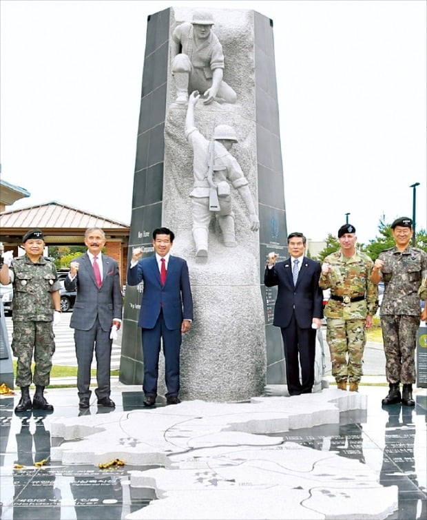 < 평택 험프리스 기지에 ‘한·미동맹 상징 조형물’  > 경기 평택 험프리스 주한미군 기지에서 10일 ‘한·미 동맹 상징 조형물’ 제막식이 열렸다. 조형물은 ‘함께하는 내일, 아름다운 동행’이라는 주제로 한·미 장병이 협력해 역경을 극복하는 모습을 형상화했다. 왼쪽부터 박한기 합동참모본부 의장, 해리 해리스 주한 미국대사, 제임스 김 주한미국상공회의소 회장, 정경두 국방부 장관, 로버트 에이브럼스 한미연합군사령관, 최병혁 한미연합군 부사령관.  /국방부 제공 