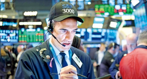 < S&P500 장중 첫 3000 돌파 > 제롬 파월 미국 중앙은행(Fed) 의장이 10일(현지시간) 금리 인하를 시사하자 미국 3대 주가지수가 일제히 사상 최고치를 기록했다. ‘S&P500지수 3000 돌파’를 기원하는 모자를 쓴 중개인이 이날 뉴욕증권거래소(NYSE) 객장에서 주문을 처리하고 있다.
/AFP연합뉴스