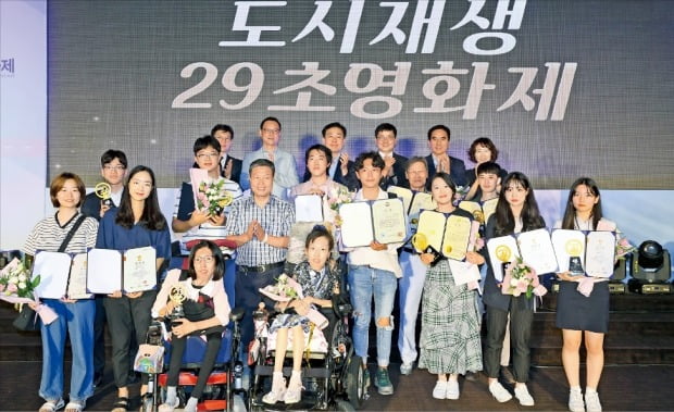 ‘도시재생 29초영화제’ 시상식이 16일 서울 청파로 한국경제신문사 다산홀에서 열렸다. 안충환 국토교통부 국토도시실장(맨 뒷줄 왼쪽 세 번째), 한병홍 LH(한국토지주택공사) 도시재생본부장(다섯 번째), 박성완 한국경제신문 편집국 부국장(여섯 번째)이 수상자들과 함께 기념촬영하고 있다.  /강은구  기자  egkang@hankyung.com