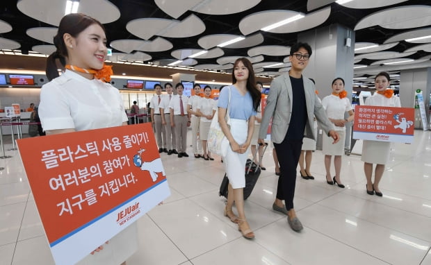 5일 서울 강서구 김포국제공항 제주항공 국내선 카운터 앞에서 신입 승무원들이 '플라스틱 줄이기'캠페인을 하고 있다. 제주항공은  7월부터 '북극곰 살리기'를 주제로 기내 음료용 플라스틱 컵과 빨대를 없애고 종이컵과 종이 빨대 사용한다. /김범준기자 bjk07@hankyung.com
 