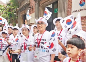 독립운동 사적지 탐방에 나선 초등학생들과 김명환 회장이 지난 14일 중국 상하이 임시정부 청사 기념관에서 태극기를 흔들고 있다. 연합뉴스 