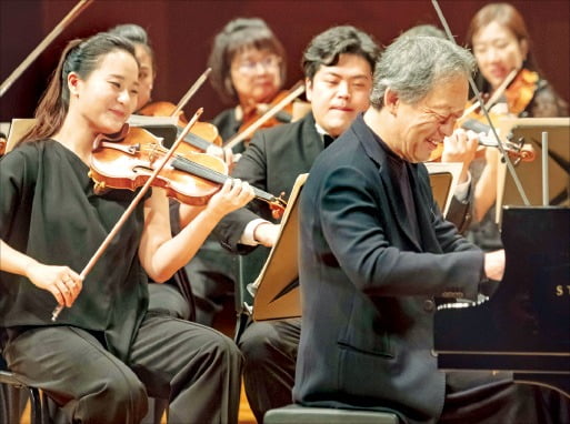 지휘자 정명훈(오른쪽)이 원코리아오케스트라(악장 임지영·왼쪽)와 함께 모차르트 피아노 협주곡 23번을 연주하고 있다.  /크레디아 제공 