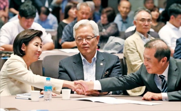 나경원 자유한국당 원내대표(왼쪽)와 김병준 전 한국당 비상대책위원회 위원장이 20일 서울 세종대로 프레스센터에서 열린 ‘대한민국 위기 극복 대토론회’에 참석해 악수하고 있다. 가운데는 정의화 전 국회의장.  /연합뉴스 