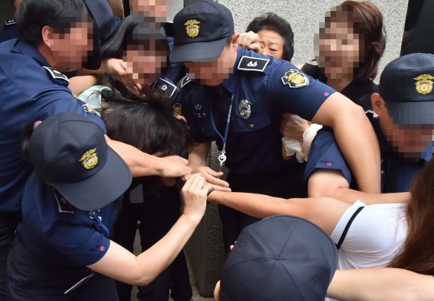 전 남편 살해 혐의로 구속기소 된 고유정이 12일 오전 제주지법에서 첫 재판을 받고 나와 호송차에 오르기  전 한 시민에게 머리채를 잡히고 있다 (사진=연합뉴스)