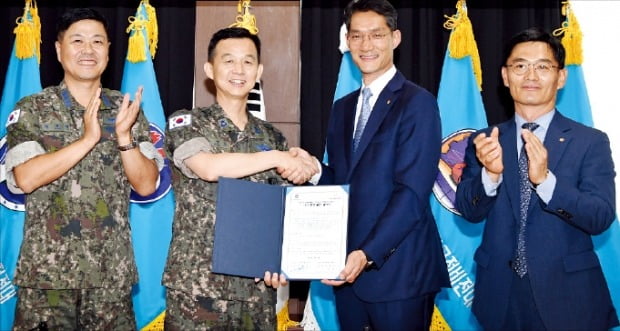 윤병호 제16전투비행단 단장(왼쪽 두 번째)과 강형석 한화에어로스페이스 상무(세 번째)가 지난 4일 경북 예천군 비행단 본부에서 ‘1사1병영’ 협약서에 서명한 뒤 기념촬영하고 있다.  /허문찬 기자 sweat@hankyung.com 