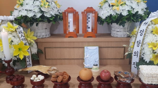 지난 6월 비영리단체 '나눔과나눔'이 지원한 무연고자들의 장례식. 베이비박스에서 발견돼 어린이병원에서 숨진 아기의 명패 앞에 내복과 바나나 우유가 놓여져 있다. 나눔과나눔 제공
