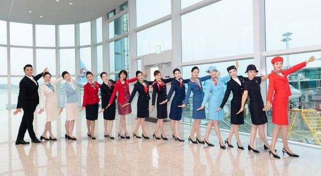 대한항공 객실승무원들이 역대 유니폼 11종을 입고 기념 촬영을 하는 모습 [사진=대한항공 제공]