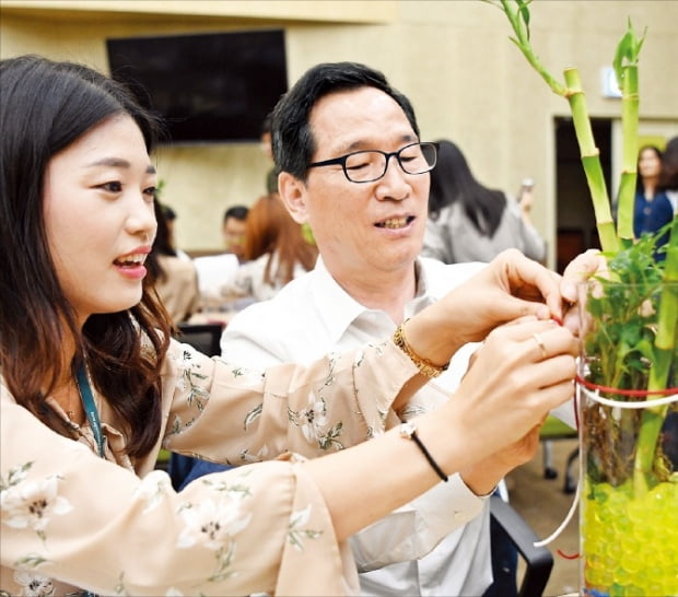 이병호 한국농수산식품유통공사(aT) 사장이 지난 9월 26일 광주·전남지역 어르신들에게 전달할 테라리움(공기정화식물 화분)을 만들고 있다.  aT센터 제공 