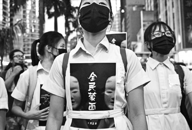 홍콩 학생들 “모두 복면을 쓰자” 홍콩 정부가 시위대의 마스크 착용을 금지하는 ‘복면 금지법’을 5일 0시부터 시행한다고 발표하자 홍콩 시민들이 4일 이에 반발하며 마스크를 쓰고 반정부 시위를 벌였다. 교복을 입은 고등학생 시위대가 “모두 복면을 써라”고 쓰인 인쇄물을 가슴에 붙인 채 도심을 행진하고 있다. AFP연합뉴스