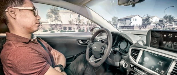 현대자동차 연구원이 미국 라스베이거스 도로를 달리는 아이오닉 자율주행차 운전석에 앉아 양손을 운전대에서 뗀 채 자율주행 기능을 시험하고 있다.  현대차그룹 제공 
