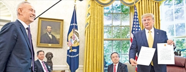 < 활짝 웃는 중국 무역협상단 대표 > 도널드 트럼프 미국 대통령(오른쪽)이 지난 11일 미국 워싱턴DC 백악관 집무실에서 중국 무역협상단 대표인 류허 부총리(왼쪽)로부터 전달받은 시진핑 국가주석의 친서를 취재진에게 보여주고 있다. /EPA연합뉴스