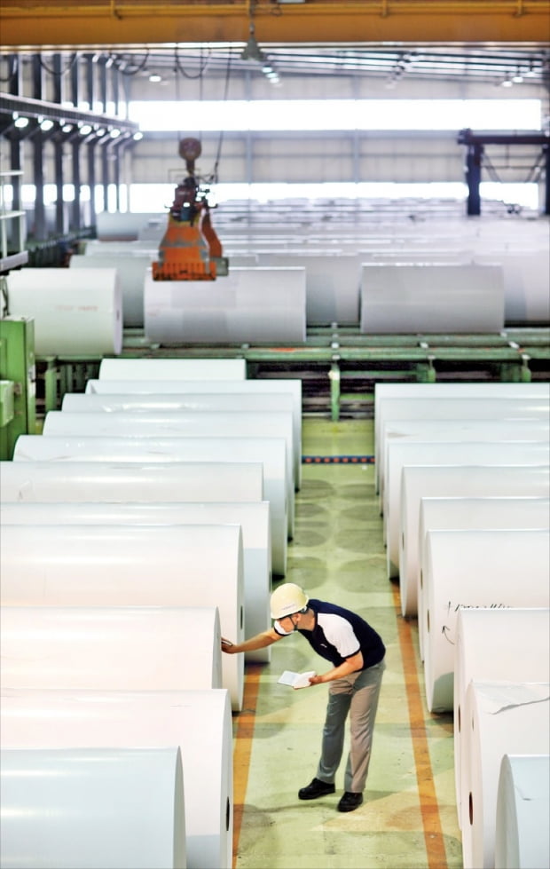 한솔제지 공장에서 근무 중인 직원이 롤 형태로 보관 중인 종이 제품의 상태를 점검하고 있다.  