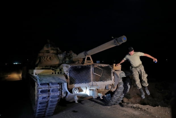 터키군 탱크가 8일(현지시간) 시리아와 접하고 있는 남동부 샨르우르파주 국경지역의 새 진지에 도착하자 한 장교가 밖으로 뛰어내리고 있다. /사진=연합뉴스