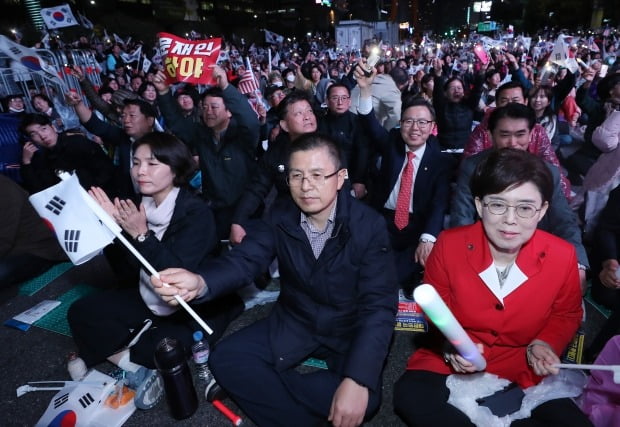 자유한국당 황교안 대표와 전희경(왼쪽)·최연혜(오른쪽) 의원이 지난 25일 오후 서울 광화문광장에서 문재인하야범국민투쟁본부 주최로 열린 제3차 범국민투쟁대회에 참가해 태극기를 흔들고 있다.(사진=연합뉴스)