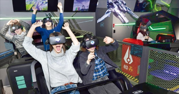 가상현실(VR) 게임이 국내 게임업체들의 새 수익원으로 부상할 전망이다. VR 기기를 쓴 이용자들이 VR 게임을 즐기고 있다.  한경DB 