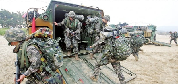 인구 구조 변화에 따른 전력 공백을 메우기 위한 대안으로 여권에서 모병제 도입을 적극 검토하고 있다. 사진은 해군·해병대 합동상륙훈련에 참가한 장병들이 장갑차에서 내려 이동하는 모습.  한경DB 