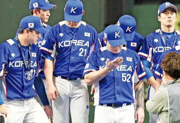 < 아쉬운 마음에… > 한국 야구대표팀이 17일 일본 도쿄돔에서 열린 2019 세계야구소프트볼연맹(WBSC) 프리미어12 슈퍼라운드 결승전에서 일본에 3-5로 역전패하며 준우승을 차지했다. 이날 경기에서 4타수 무안타로 침묵한 박병호(앞줄 오른쪽)가 시상대에 올라 눈물을 닦고 있다.  /연합뉴스 