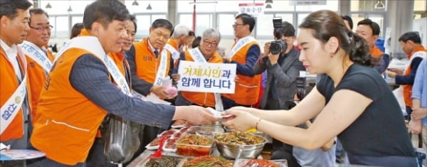 김윤식 신협중앙회장이 조선업 경기침체로 고용위기지역에 선정된 경남 거제시의 전통시장을 찾아 상인들과 악수하고 있다.  신협중앙회  제공
 