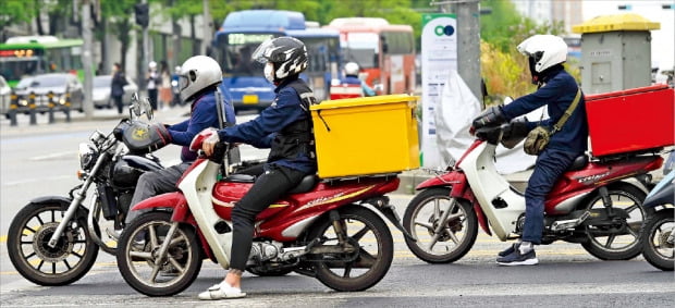 배달대행 앱(응용프로그램)을 기반으로 하는 배달기사 등 ‘긱 이코노미(Gig Economy)’ 분야 노동자에 대해 ‘근로자’의 법적 지위를 인정하는 판결이 최근 잇따르면서 논란이 커지고 있다. 지난 23일 배달 오토바이 운전자들이 서울 이화여대 앞 사거리를 오가는 모습.  /김범준 기자  bjk07@hankyung.com 