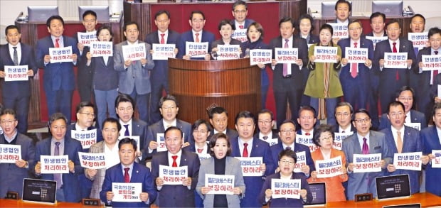 나경원 원내대표(맨 앞)를 비롯한 자유한국당 의원들이 29일 국회 본회의장에서 ‘필리버스터 보장하라’ ‘본회의를 개의하라’ 등의 구호를 외치고 있다. 한국당이 이날 본회의에 상정된 199개 안건에 대해 필리버스터를 신청하자 더불어민주당이 불참을 결정하면서 본회의는 무산됐다.  연합뉴스 