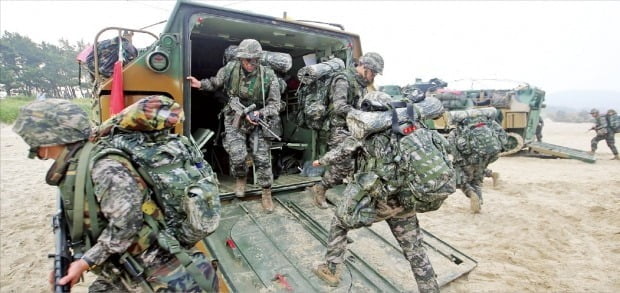 인구 구조 변화에 따른 전력 공백을 메우기 위한 대안으로 여권에서 모병제 도입을 적극 검토하고 있다. 사진은 해군·해병대 합동상륙훈련에 참가한 장병들이 장갑차에서 내려 이동하는 모습. 한경DB