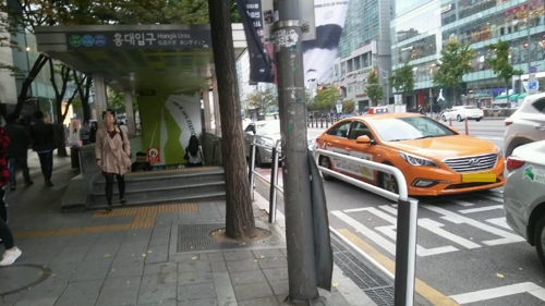 혼잡한 홍대입구역 8번출구 앞 보도펜스 설치