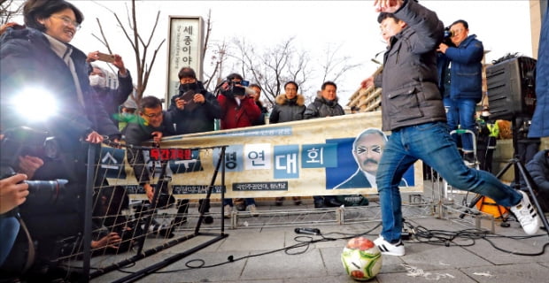 국민주권연대와 청년당 관계자들이 13일 서울 KT광화문 빌딩 앞에서 ‘해리스 참수 경연대회’를 열고 해리 해리스 주한 미국 대사의 얼굴 사진이 붙은 공을 차는 퍼포먼스를 하고 있다.   연합뉴스 