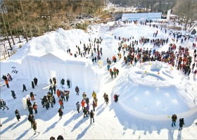 관광객들이 태백산 눈꽃축제에서 눈 조각상과 전시물을 감상하고 있다. 