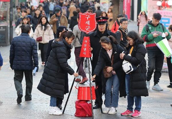 11일 서울 중구 명동에서 학생들이 성금을 자선냄비에 넣고 있다/사진=연합뉴스