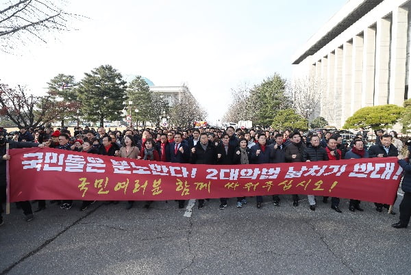 자유한국당 황교안 대표와 심재철 원내대표 등 의원들이 18일 국회 본관 앞에서 열린 '공수처법·선거법 날치기 저지 규탄대회'를 마치고 집회 참석을 위해 국회 밖으로 나가고 있다. 사진=연합뉴스