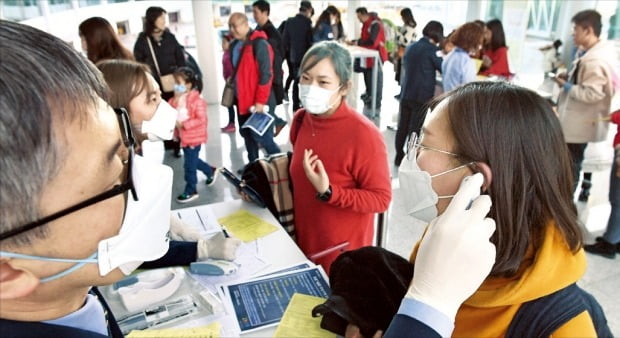 질병관리본부는 지난 19일 중국 우한에서 인천국제공항으로 입국한 중국인 여성 A씨(35)가 ‘우한 폐렴’으로 불리는 신종 코로나바이러스에 감염됐다고 20일 발표했다. 검역원들이 이날 인천공항 제2터미널 입국장에서 우한에서 입국한 사람들의 발열 여부를 검사하고 있다. 
 /김영우  기자  youngwoo@hankyung.com 