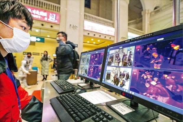 < 중국 ‘우한 폐렴과의 전쟁’ > 중국 후베이성 우한에서 발생한 신종 코로나바이러스가 미국까지 확산됐다. 중국에선 22일 하루에만 감염자가 150명 이상 늘었다. 중국 정부는 총력 대응 체제를 가동하기 시작했다. 우한 한커우역에서 직원이 모니터로 승객들의 발열 상태를 점검하고 있다. AFP연합뉴스