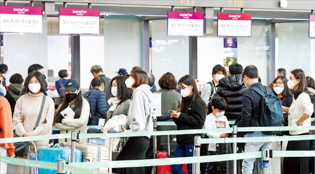 < 마스크 쓴 채 출국 > 설 연휴를 맞아 해외로 떠나는 여행객들이 23일 인천국제공항에서 중국발(發) 신종 코로나바이러스로 인한 ‘우한 폐렴’ 전염을 우려해 마스크를 쓴 채 출국수속을 기다리고 있다.  허문찬 기자 sweat@hankyung.com 