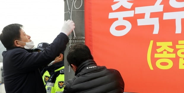 31일 중국 우한 교민이 격리 수용될 충북 진천 국가공무원인재개발원 앞에서 진천 주민들이 수용 반대를 요구하는 현수막을 자진 철거하고 있다. 사진=연합뉴스