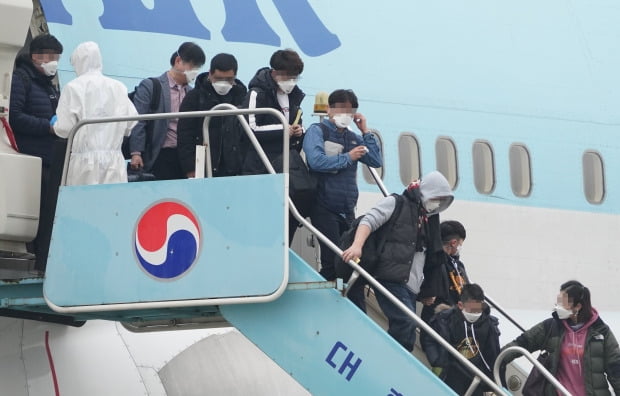 중국 후베이성 우한 거주 교민들을 태운 2차 전세기가 지난 1일 오전 김포공항에 도착했다. 마스크를 쓴 탑승 교민들이 트랩을 내려오고 있다. /연합뉴스 