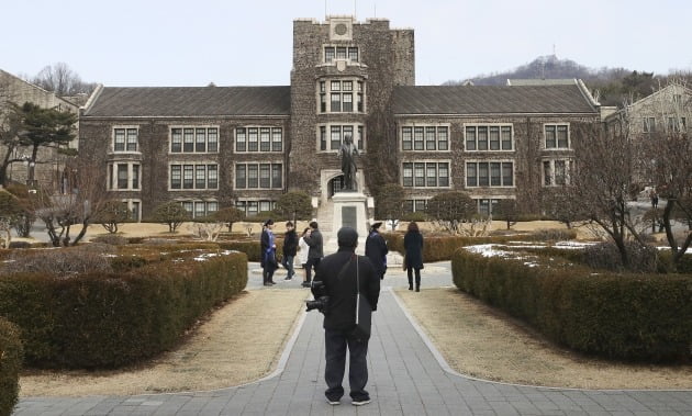 19일 서울 연세대학교에서 한 사진사가 학생들의 졸업사진 촬영 모습을 보고 있다. 연세대는 코로나19 확산 방지를 위해 2월 학위수여식을 취소하고 이날부터 희망 학생들에게 졸업 가운과 학사모를 대여하고 있다. 2020.2.19 [사진=연합뉴스]