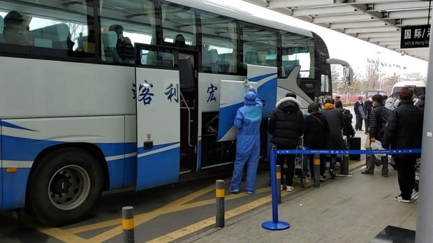 인천발 제주항공 7C8501편 승객들이 지난 25일 중국 산둥성 웨이하이공항에서 당국의 격리조치를 위해 준비된 버스에 타고 있다.  /연합뉴스
