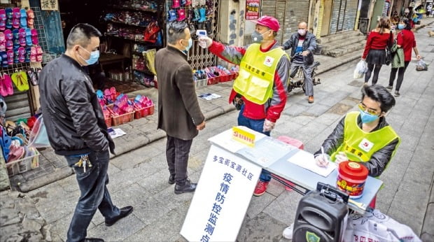 < 골목에서도 발열 체크 > 중국 광둥성 광저우시 보건 공무원이 시민들의 체온을 재고 있다. 광둥성의 ‘코로나19’ 확진자는 14일 기준 1261명으로, 후베이성(5만1986명 확진)에 이어 중국에서 두 번째로 많다. EPA연합뉴스