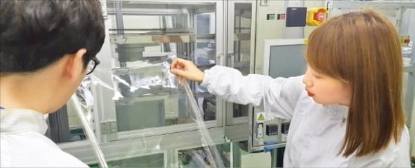 코오롱인더스트리는 작년 세계 최초로 투명 폴리이미드 필름을 양산했다. 경북 구미 코오롱인더스트리 공장에서 직원들이 제품을 검사하고 있다.  코오롱  제공
 