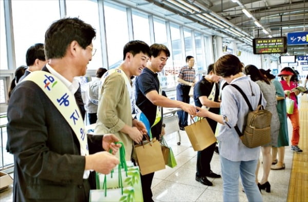 한국농어촌공사 직원들이 지난달 23일 광주 송정역에서 시민들에게 떡을 나눠주며 농지연금을 홍보하고있다. 한국농어촌공사 제공 