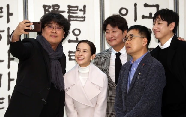 영화 '기생충' 봉준호 감독과 배우 송강호, 조여정, 이선균 등이 20일 청와대에서 문재인 대통령 초청 오찬에 앞서 기념촬영을 하고 있다. 앞줄 오른쪽은 봉 감독의 대학동기인 육성철 청와대 행정관.사진=연합뉴스