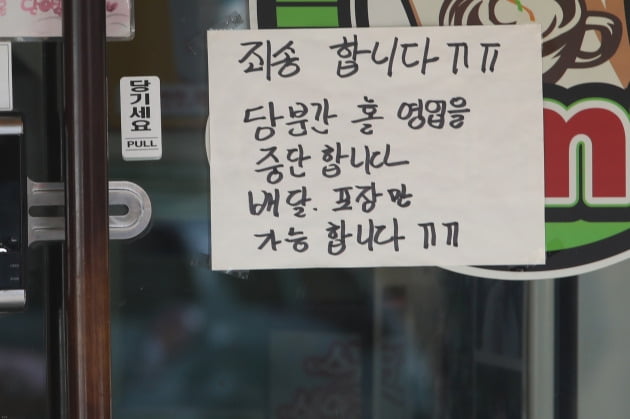 지난 5일 대전시 동구 우송대 앞 먹거리 상가의 한 음식점에 홀영업을 중단하고 배달, 포장만 한다는 안내가 붙어있다.  /연합뉴스